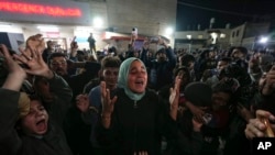 Palestinians celebrate the announcement of a cease-fire deal between Hamas and Israel in Deir al-Balah, central Gaza Strip, on January 15