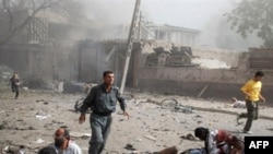 Survivors run past fallen bystanders at the scene of a suicide bombing outside the Indian Embassy in Kabul